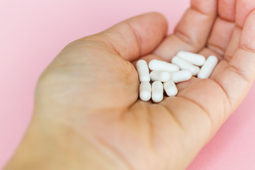 Capsules of medicine in hand. A handful of capsules close-up. Medical background