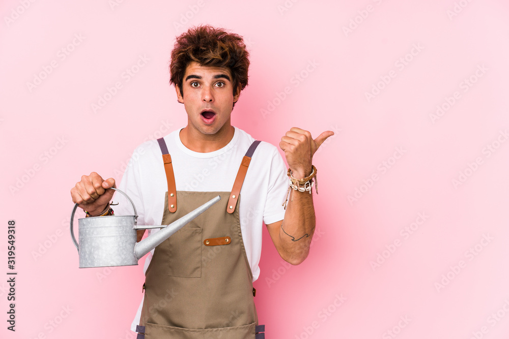 Wall mural Young caucasian gardener man isolated pointing to the side