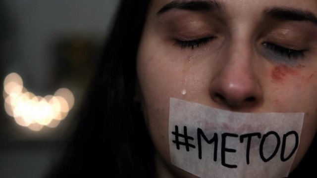 Portrait of a woman with a sticker on her mouth that says "#metoo". Me Too movement.