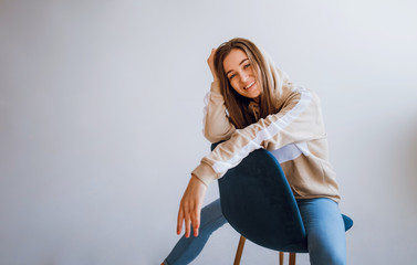 Beautiful stylish girl sitting on a chair. Portrait of beautiful smiling girl.