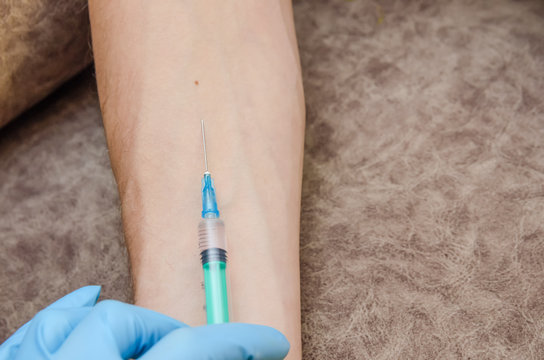 female doctor conducts a Mantoux test for a man in a clinic. Hand and syringe close-up