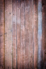 Toned photo of an old fence made of nailed boards. Dark brown background for sites and layouts with vignette.