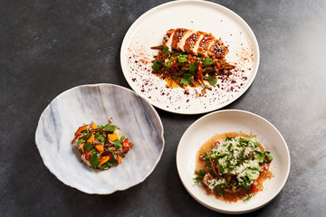 Set of various plates of food on a gray table background with copy space