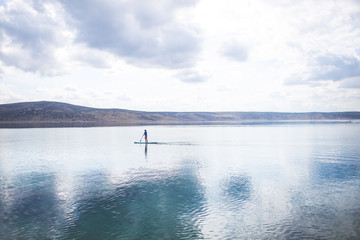 Obraz premium young woman SUP boarding