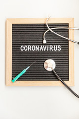 Text phrase Coronavirus syringe and stethoscope on black letter board background. Novel coronavirus 2019-nCoV, MERS-Cov middle East respiratory syndrome coronavirus originating in Wuhan China