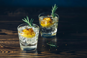 Charred Lemon, Rosemary and Coriander Gin and Tonic is a flavors are perfectly balanced refreshing cocktail. on dark background, close up.