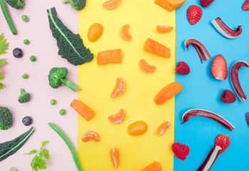 top view of color fruit  and vegetables on pink,yellow and blue background