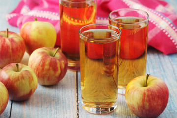 Glasses with apple juice and ripe apples