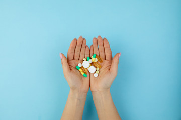 woman holds many different pills in her hands
