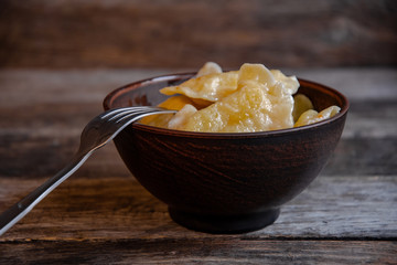 Homemade dumplings in clay pots on the kitchen table, fork and folklor napkin.
