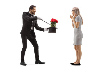 Magician making a magic trick with flowers and a hat in front of a surprised young woman