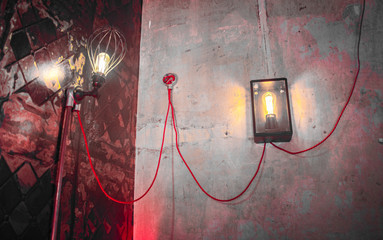 Rustic lamps mounted on grungy concrete walls in a dingy bar corner