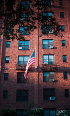 American flag fluttering on a red brick apartment building in Midtown Manhattan, New York City
