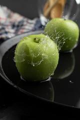 Photography of Verdews apples in black and water background