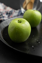 Photography of Verdews apples in black and water background