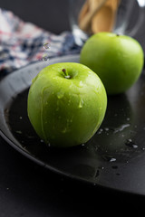 Photography of Verdews apples in black and water background