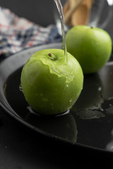 Photography of Verdews apples in black and water background