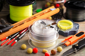 Fishing rods and spinnings in the composition with accessories for fishing on the old background on...