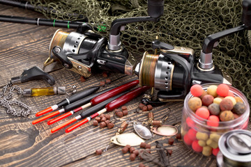Fishing rods and spinnings in the composition with accessories for fishing on the old background on...