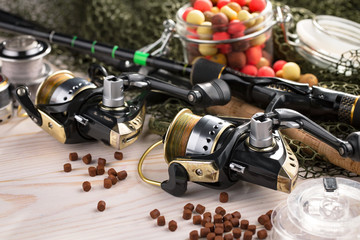 Fishing rods and spinnings in the composition with accessories for fishing on the old background on...
