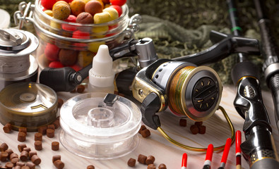 Fishing rods and spinnings in the composition with accessories for fishing on the old background on...