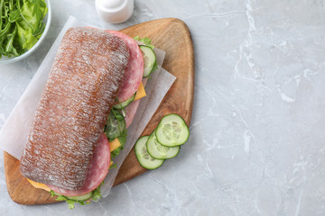 Tasty sandwich with ham on grey table, flat lay. Space for text