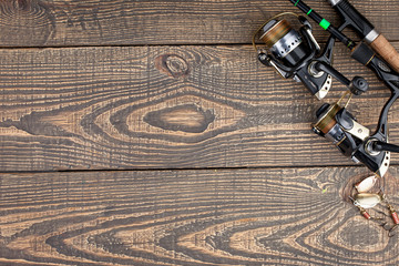 Fishing rods and spinnings in the composition with accessories for fishing on the old background on the table © vizafoto