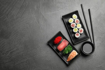 Set of delicious sushi and rolls on grey table, flat lay. Space for text