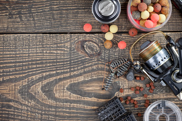 Fishing rods and spinnings in the composition with accessories for fishing on the old background on...
