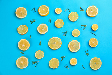 Lemonade layout with juicy lemon slices and rosemary on blue background, top view