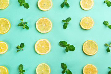 Lemonade layout with juicy lemon slices and mint on turquoise background, top view