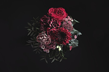Beautiful fresh flowers on black background. Floral card design with dark vintage effect