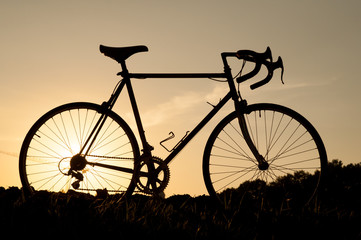 Fototapeta na wymiar Bicycle silhouette in front of summer sky