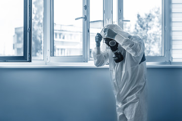 Man wearing protective biological suit and gas-mask due to mers coronavirus global pandemic warning...