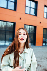 young pretty teenage girl posing cheerful happy smiling wearing street style outside in europe city, lifestyle people concept