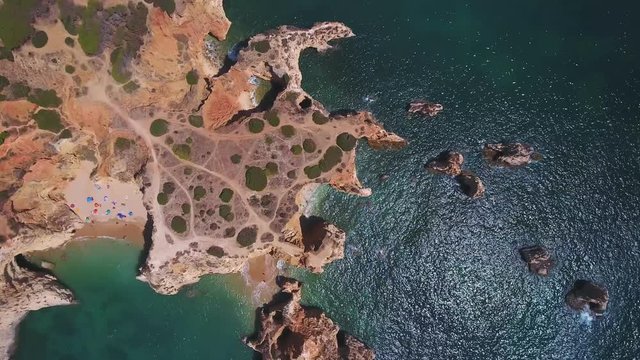 A magical aerial top view of the coast of beaches Vao Alemao, with tourists in Portugal Algarve Portimao.