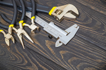 Necessary set of tools for plumbers on wooden black boards