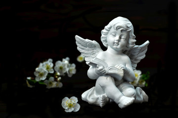 Guardian angel and spring flowers isolated on black background