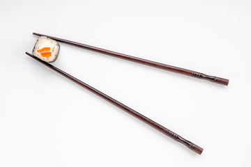 roll between chopsticks for sushi on a light background for the menu