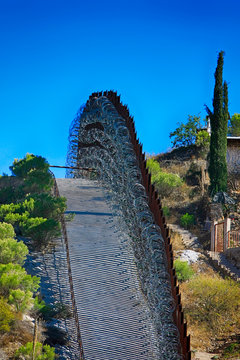The US-Mexican border wall with layers of razor wire at Nogales AZ