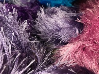Texture of different sharpness from fluffy bright yarn of lilac and pink colors. Mobile photo with store lighting.