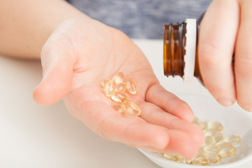 Garlic oil supplements in hands from bottle