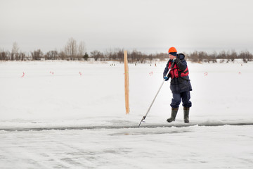 Worker rafts ice blocks along a canal carved in a frozen lake