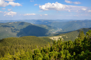 Mikulichyn village in the valley of the Carpathian Mountains view from the top of Mount Khomyak at an altitude of 1542 meters. Hutsul wooden houses at the foot of the mountains. Ukraine