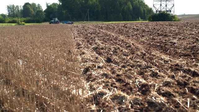 Tractor discing stubble field. Agricultural machine cultivating farm land soil