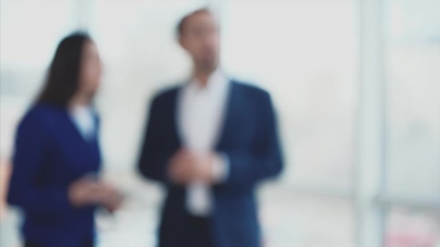 Blurred focus. Close up. Business workers are discussing issues. Copy space. Woman is noting important information. Successful agreement. 4K.