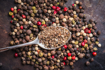 Mixed peppercorns on the rustic background. Selective focus. Shallow depth of field.