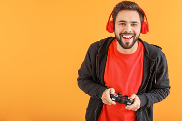 Man playing video game on color background