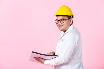 Industry worker or engineer working an architect builder studying layout plan serious civil engineer working with reading on blueprint isolated on pink blank copy space studio background,indoor studio