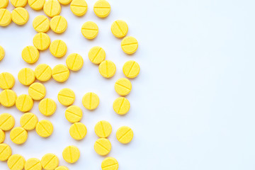 Yellow tablets of Paracetamol on white background.